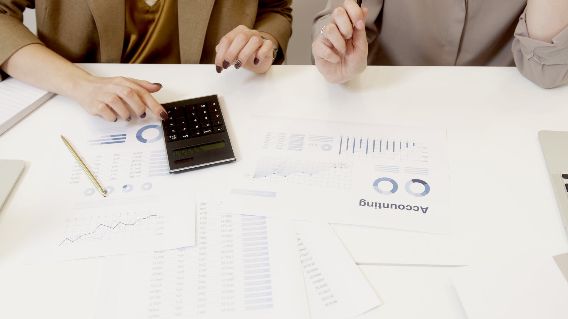 two women working with accounting data on table